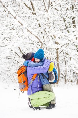 Çocuk anne sarılmak. Bir çocuk annesi bir kış yürüyüş ile. Bir çocuk annesini öper. Kadın oğlunu destekler. Annelik. Aile birlikte vakit geçiriyor. Aile değerleri.