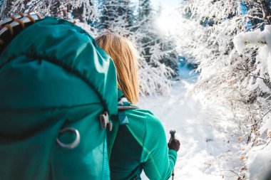 Sırt çantası kış dağlarda olan kadın. Doğal yerlere seyahat. Trekking sopa bir sarışınla portresi. Bir turist karlı bir orman yoluyla yürür. Etkin boş ve yaşam tarzı. Gülümseyen kız.
