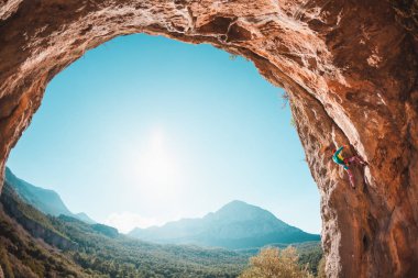 Bir kadın bir güzel dağ manzarası kayaya tırmanıyor. Doğada tırmanma. Fitness açık havada. Ekstrem Sporlar. Doğal bir rahatlama atlet trenlerde. Türkiye'de dağcılık. Mağara.