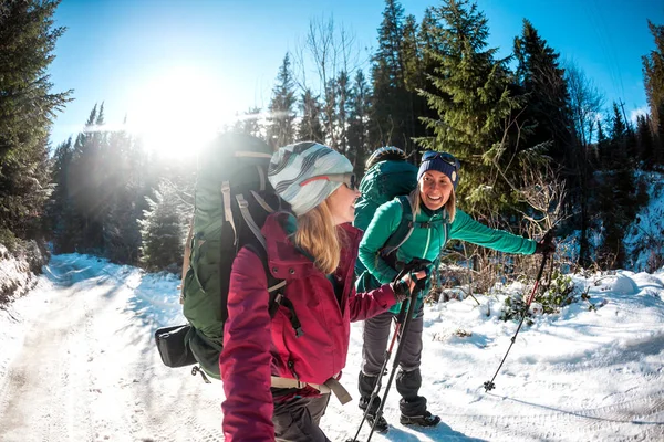 Dos Mujeres Una Caminata Invierno Las Amigas Con Bastones Trekking —  Fotos de Stock