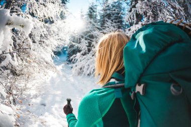 Sırt çantası kış dağlarda olan kadın. Doğal yerlere seyahat. Trekking sopa bir sarışınla portresi. Bir turist karlı bir orman yoluyla yürür. Etkin boş ve yaşam tarzı. Gülümseyen kız.