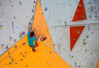 Eğitim spor tırmanma City. Güçlü bir kadın yapay arazi üzerinde tırmanma bir rota tırmanıyor. İnce kız spor dahil.