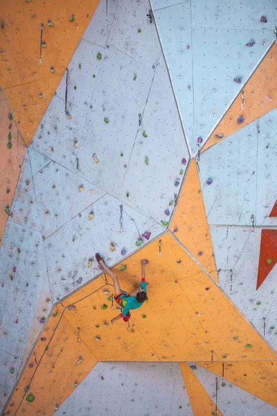 人工の救済に登山列車 女性は ストリートのクライミングウォールに登山道を登っていきます ホールでのトレーニング 強い女の子スポーツに関与して — ストック写真