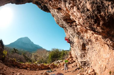 Arkadaşlar kaya tırmanışı nişanlandık. Bir kadın zor bir tırmanış rota üstesinden gelir. Fitness doğada. Takım çalışması. Ortak sigorta.