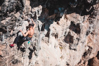 Bir kadın rock tırmanıyor. Doğada tırmanma. Fitness açık havada. Aktif yaşam tarzı. Ekstrem Sporlar. Doğal bir rahatlama atlet trenlerde. Türkiye'de dağcılık.