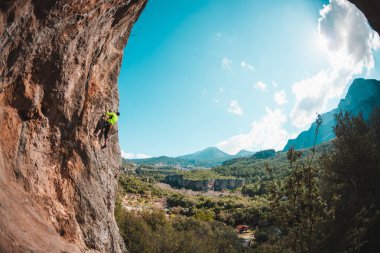 Bir adam bir dağ manzarasına karşı kayaya tırmanır. Sporcu doğal bir rahatlama ile antrenman yapar. Türkiye 'de tırmanış. Kemer şeklinde bir kaya. Mağara. Dağcı zor bir yolun üstesinden gelir..