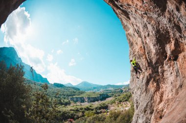 Bir adam bir dağ manzarasına karşı kayaya tırmanır. Sporcu doğal bir rahatlama ile antrenman yapar. Türkiye 'de tırmanış. Kemer şeklinde bir kaya. Mağara. Dağcı zor bir yolun üstesinden gelir..