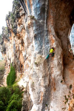 Bir adam kaya tırmanıyor. Doğada tırmanma. Fitness açık havada. Aktif yaşam tarzı. Ekstrem Sporlar. Doğal bir rahatlama atlet trenlerde.