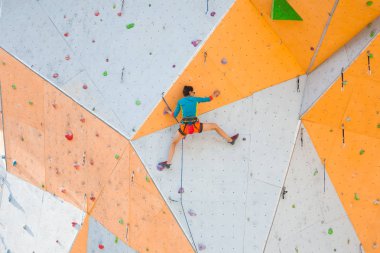 Yapay bir rahatlama dağcı trenlerde. Bir kadın bir tırmanma yol sokak tırmanma duvarı üzerinde tırmanıyor. Eğitim salonunda. Güçlü kız spor dahil.