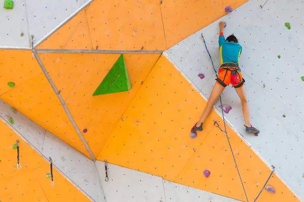 在城市攀岩健身房训练 一个强壮的女人在人工地形上攀爬路线 参与体育活动的苗条女孩 — 图库照片