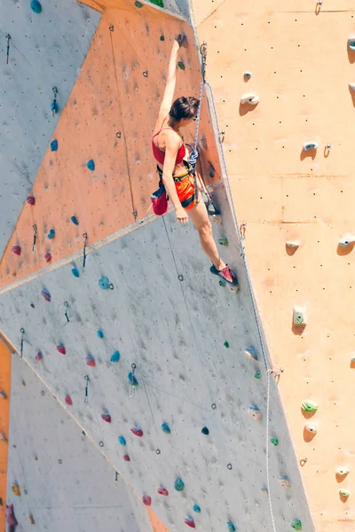 クライミングジム市で研修 強い女性は 人工地形に登山道を登っていきます スリムな女の子のスポーツに関与して — ストック写真