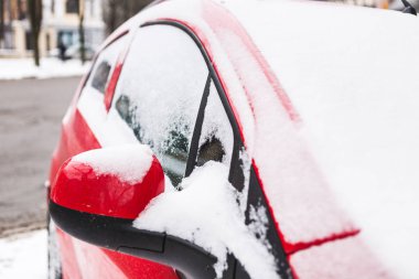 Kırmızı araba kar kaplı. Park edilmiş araç kapatın. Makine hoarfrost ile kaplıdır. Kış kar yağışı.