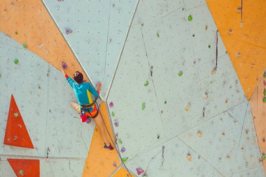 Eğitim spor tırmanma City. Güçlü bir kadın yapay arazi üzerinde tırmanma bir rota tırmanıyor. İnce kız spor dahil.