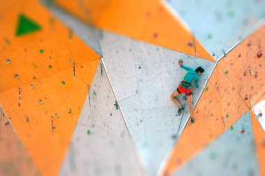 Yapay bir rahatlama dağcı trenlerde. Bir kadın bir tırmanma yol sokak tırmanma duvarı üzerinde tırmanıyor. Eğitim salonunda. Güçlü kız spor dahil.