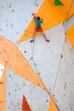 Yapay bir rahatlama dağcı trenlerde. Bir kadın bir tırmanma yol sokak tırmanma duvarı üzerinde tırmanıyor. Eğitim salonunda. Güçlü kız spor dahil.