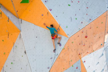 Yapay bir rahatlama dağcı trenlerde. Bir kadın bir tırmanma yol sokak tırmanma duvarı üzerinde tırmanıyor. Eğitim salonunda. Güçlü kız spor dahil.