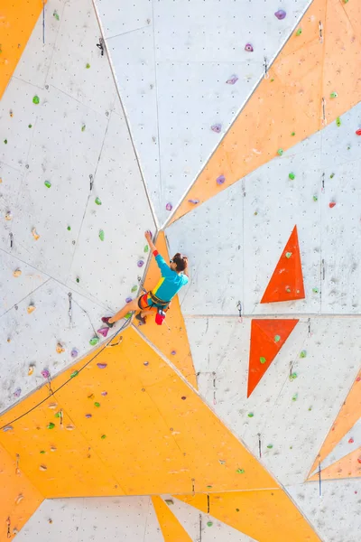 人工の救済に登山列車 女性は ストリートのクライミングウォールに登山道を登っていきます ホールでのトレーニング 強い女の子スポーツに関与して — ストック写真