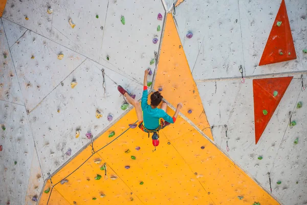 クライミングジム市で研修 強い女性は 人工地形に登山道を登っていきます スリムな女の子のスポーツに関与して — ストック写真