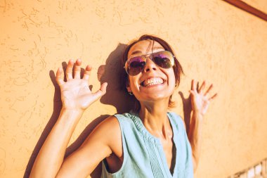 Bir kadın portresi. Kahverengi bir duvar arka plan üzerinde kız. Gözlük ince bir kadınla bir şehir sokak teşkil etmektedir. Güzel bir esmer bir şehir sokak yürüyor.