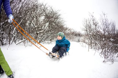 Bir kadın bir çocuk bir kızağa alır. Bir çocuk annesi kış ormanı ile yürür. Çocuk ile bir kızakta kar üzerinden gidiyor. Kış tatili. Anne ile eğlenceli eğlence.