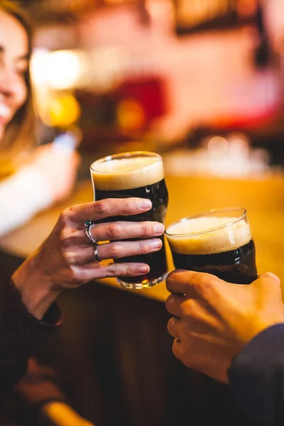 Kadın ve adam bira içmek. Arkadaşlar bir barda tanıştım. Karanlık bira iki kadeh. Bir tarihte çift.