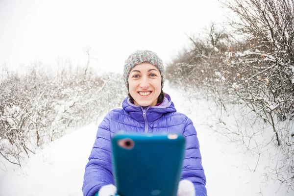Smartphone Kobieta Robi Zdjęcie Telefon Komórkowy Lesie Zimowym Uśmiechnięta Dziewczyna — Zdjęcie stockowe
