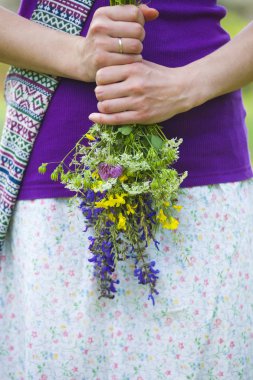 Kız kır çiçekleri buketi düzenliyor. Bir kadın bir çayır çiçek almaya gitti. Çiçek hediye. Yaz çimen. Köyde dinlenme.