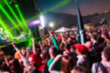 Müzik Festivali'nde kişilik bir kalabalık. İnsanlar konserde eğleniyor. Seyirciler sahne alanı yakınında. Bulanıklaştırma efekti.