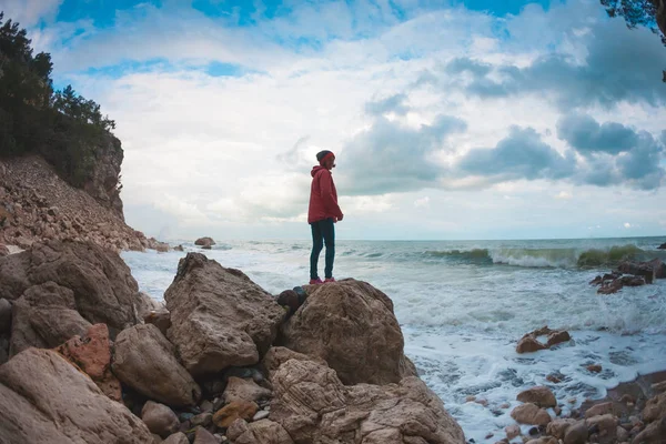 这个女孩站在海边的一块石头上 女人欣赏大海 一个人在夕阳西下的轮廓 — 图库照片