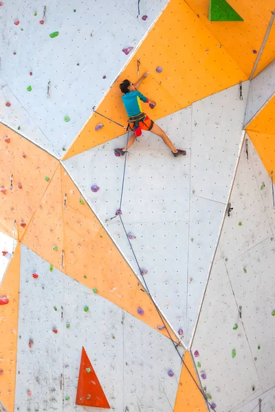 Eğitim spor tırmanma City. Güçlü bir kadın yapay arazi üzerinde tırmanma bir rota tırmanıyor. İnce kız spor dahil.