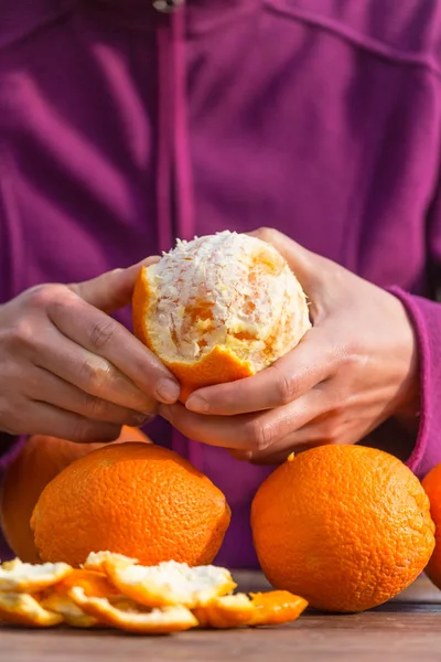 Woman peels oranges from peel. — Stock Photo, Image