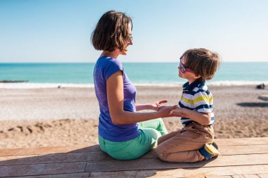 kadın oğluyla birlikte sahilde oynarken.