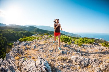 Bir kız dağlarda çalışıyor.