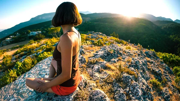 La mujer está sentada en la cima de la montaña . —  Fotos de Stock