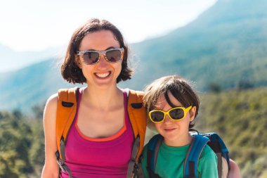 Çocuk ve annesi dağ üstüne oturuyor.