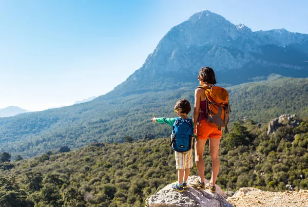 Pojken och hans mamma står på toppen av berget. — Stockfoto