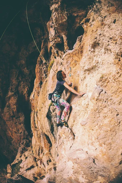 Девушка взбирается на скалу . — стоковое фото