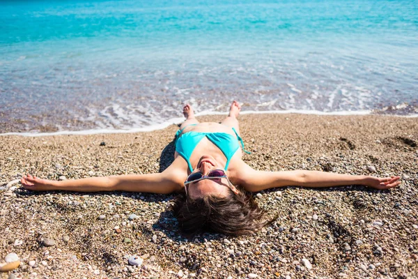 A menina toma banho de sol na praia . — Fotografia de Stock