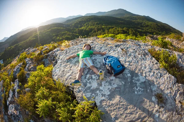 El niño yace sobre una gran piedra . — Foto de Stock