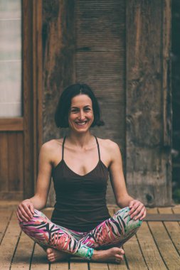 Bir kadın eski bir ahşap ev verandada yoga uygulamaları.