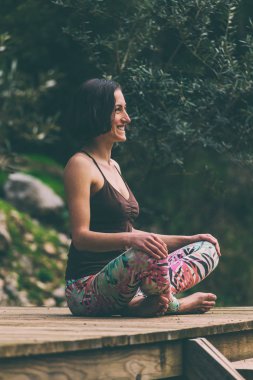 Bir kadın eski bir ahşap ev verandada oturuyor.