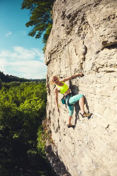 Das Mädchen erklimmt den Felsen. — Stockfoto