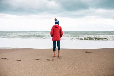 Yalınayak kadın kış denizde görünüyor.