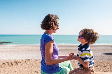 kadın oğluyla birlikte sahilde oynarken.