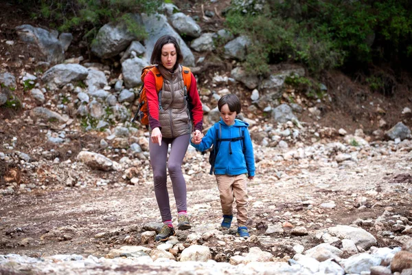 Une femme marche avec son fils à travers la forêt . — Photo