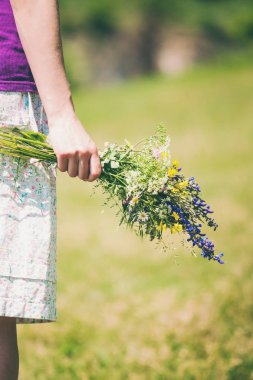 Kız kır çiçekleri buketi düzenliyor.