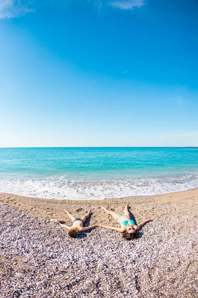 O menino com sua mãe tomar banho de sol na praia . — Fotografia de Stock