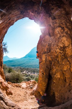 Kaya tırmanışçısı mağaraya tırmanıyor.