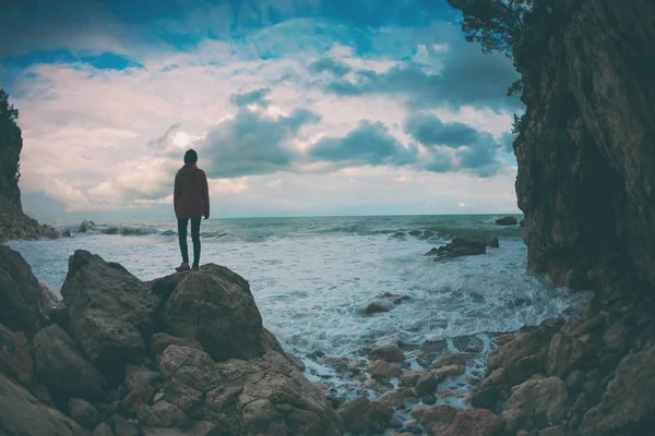 女の子は海のそばの石の上に立っている. — ストック写真