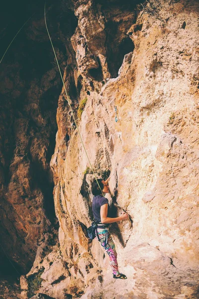 A girl climbs a rock. — Stock Photo, Image